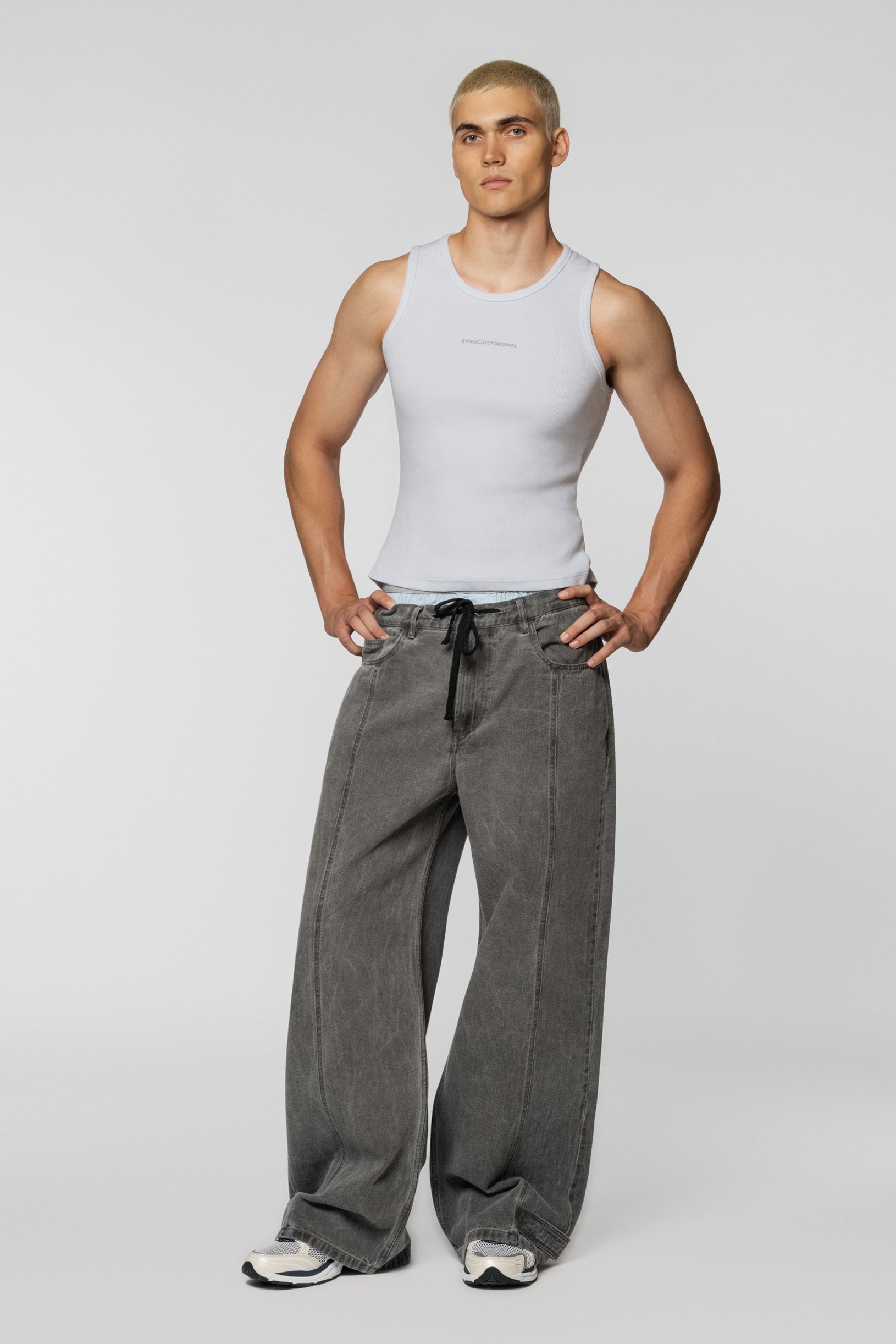 Loose grey jeans with tucks and a drawstring belt