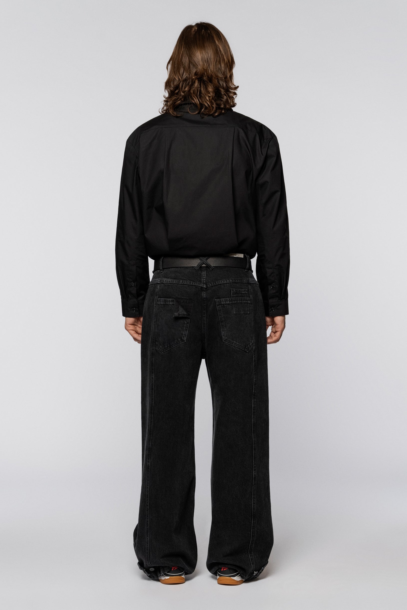 Black wide jeans with a washed effect and snap fasteners at the hem