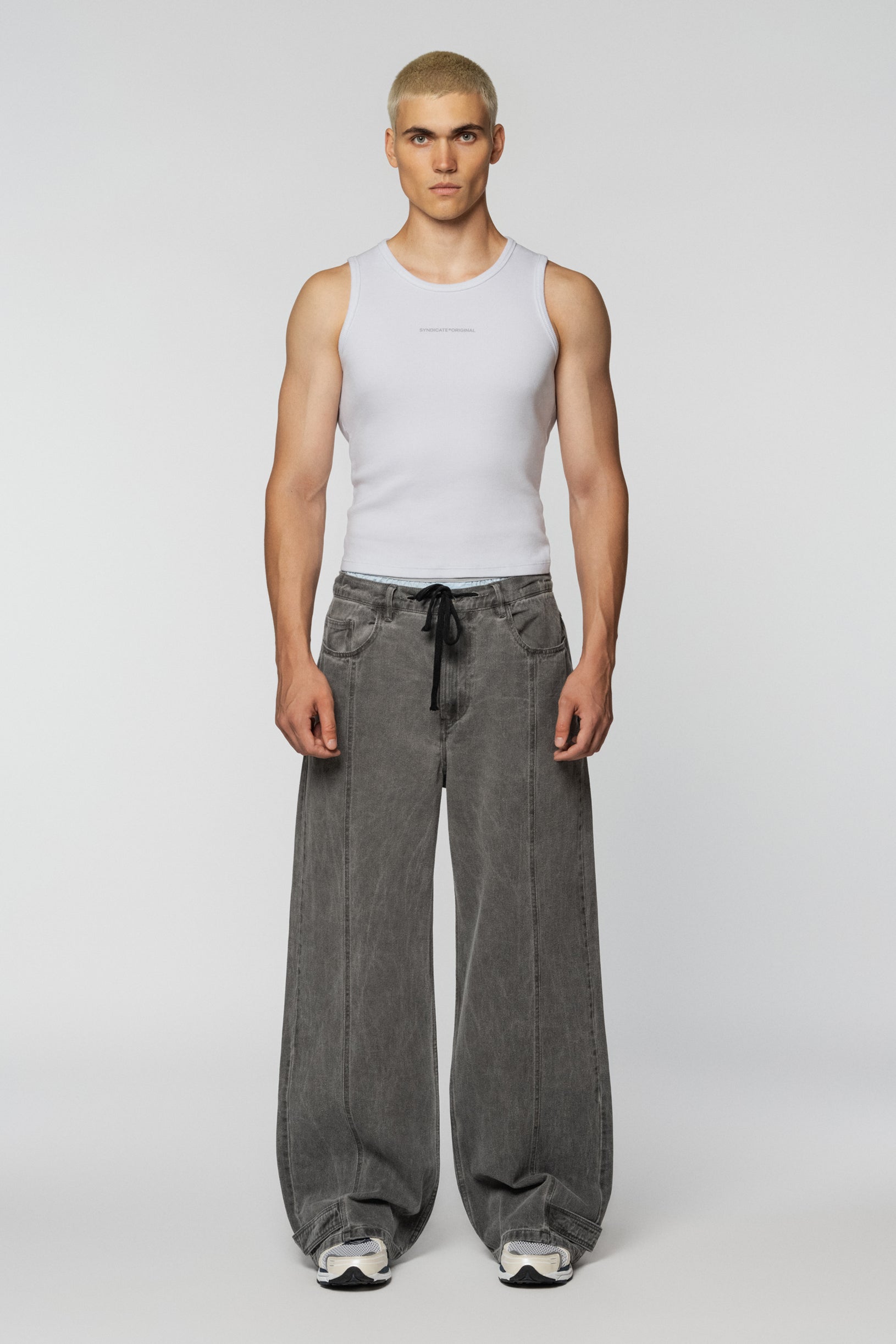 Loose grey jeans with tucks and a drawstring belt